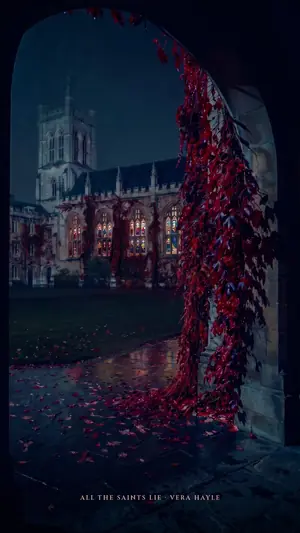 A gothic college chapel seen through a stone arch hung with red ivy